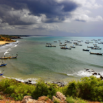 De kustlijn van Ghana met traditionele vissersbootjes.
